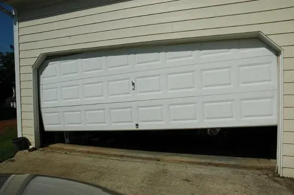 White garage door with a visible gap along its bottom edge