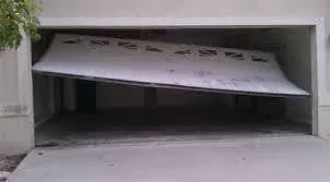 Garage door panel bent inward and partly out of its track
