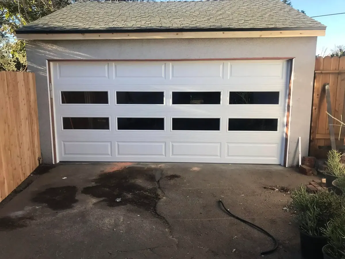 White garage door with a row of window panels closed on a detached garage