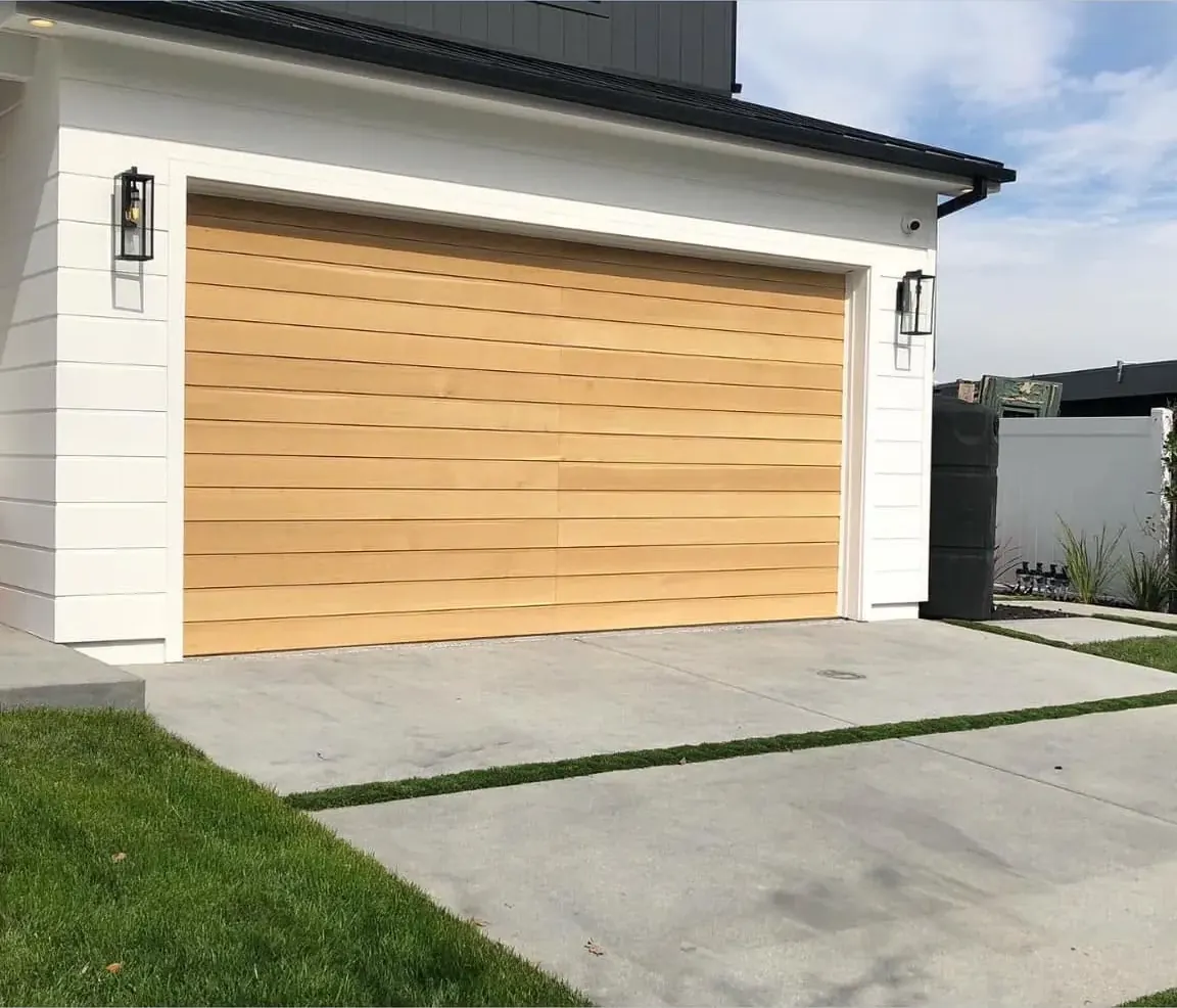 Wood-look garage door on a modern white house with a concrete driveway